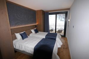 a bedroom with a bed with blue pillows and a window at Appartement de luxe les Arcs 4 chambres skis aux pieds in Arc 1800