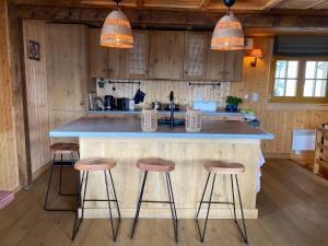 a kitchen with a large counter with stools around it at Chalet Belland in Bellwald