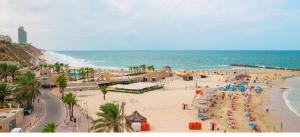 a beach with a crowd of people and the ocean at Centre studio 16 in Netanya