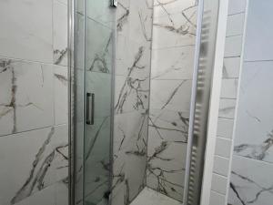 une douche avec une porte vitrée dans une salle de bain dans l'établissement Studio cosy au centre de Samoëns avec balcon - FR-1-624-183, à Samoëns