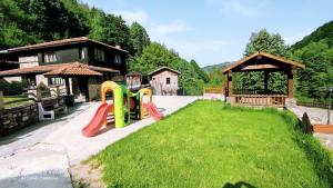 a playground in a yard next to a house at Guest House Robin Hud in Cherni Osŭm