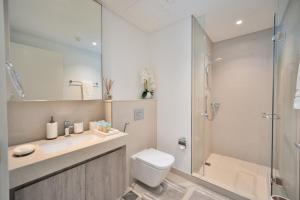 a bathroom with a shower and a toilet and a sink at Executive 2-Bedroom Apartment in Downtown views 2 with access to Dubai mall in Dubai +30 photos