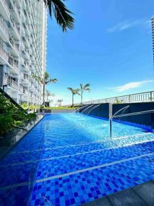 a swimming pool with blue tiles in front of a building at SMDC Coast Residences by Presto Real Estate Management near MOA, PICC, Star City and NAIA in Manila