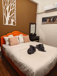an orange bed with two stuffed animals on it at CKC Homesweet in Nakhon Nayok +10 photos