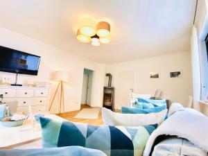 a living room with blue and white furniture and a tv at Ferienwohnung Marlene 80 Qm in Ebersburg