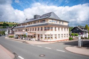 Un gran edificio blanco al costado de una calle. en Schwalbennest, en Willingen