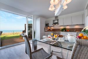 a kitchen and dining room with a glass table and chairs at Ferienwohnung Schleiperle in Olpenitz