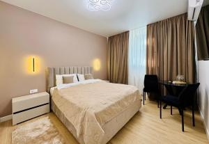 a bedroom with a bed and a desk and a table at CehovHouse in Bălţi