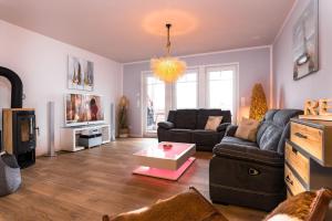 a living room with a couch and a tv at Ferienhaus Auszeit in Olpenitz