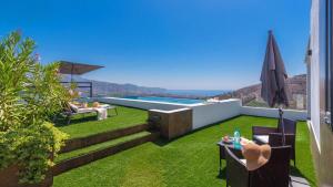 a backyard with a swimming pool and grass at Villa Alborada Torrox by Ruralidays in Torrox