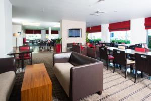 a restaurant with couches and tables and chairs at Holiday Inn Express Leeds City Centre by IHG in Leeds
