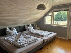 two beds in a room with two windows at Villa Seeblick in Vissefjärda