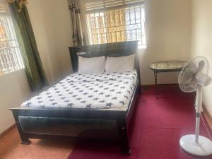 a bedroom with a bed with a fan and a window at B40Motel in Kampala