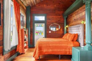 a bedroom with a bed with an orange comforter at Fleur de Tris at Bent Tree Ranch in Lampasas
