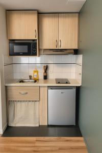 a kitchen with a sink and a microwave at BALI TOUCH - Clim , Parking privé , Wifi in Grenoble