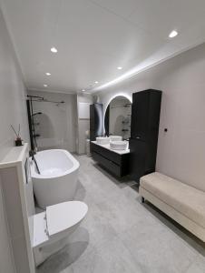ein Badezimmer mit einer Badewanne, einem WC und 2 Waschbecken in der Unterkunft Spacious Modern 3BR, Terrace, Aurora & Midnight Sun, Pets allowed, Free Parking, Close to Ski slopes, Snow Dome, Bus stop in Tromsø
