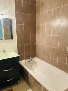 un bagno con vasca e lavandino di "Les Pâturages" Chanas - Maison Entière proche A7, 2 Chambres, 4 Personnes, Jardin Privé, Piscine & BBQ a Chanas