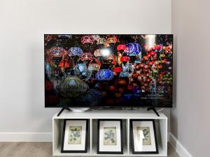 a flat screen tv sitting on top of a white table at Pass the Keys Modern 1-Bed w Free Parking Peaceful Cardiff Stay in Cardiff