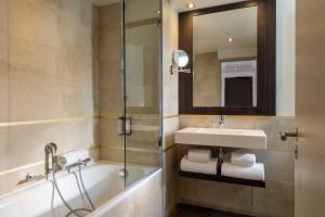 a bathroom with a tub and a sink and a shower at Hotel Villa Saxe Eiffel in Paris