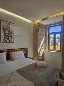 a bedroom with a large bed and a window at Palacium Charming Suites in Figueiró dos Vinhos +60 photos