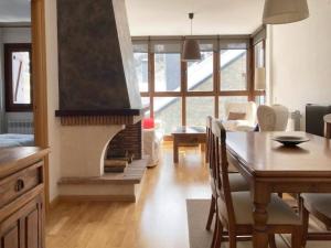 a living room with a dining table and a fireplace at Tarmañones l VISTAS l WIFI l GARAJE l TRASTERO in Escarrilla