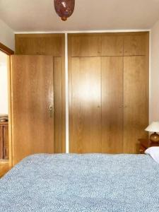 a bedroom with a large bed and wooden cabinets at Apartamento Tarmañones Vistas a la montaña in Escarrilla +17 photos