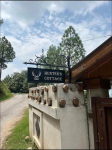 un panneau pour un café-hamburger à côté d'une route dans l'établissement Hunter's Cottage, à Ban