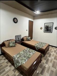 Cette chambre comprend deux lits et une horloge murale. dans l'établissement Hunter's Cottage, à Ban