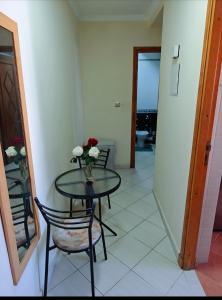 una mesa y sillas con un jarrón de flores. en Agadir city break, en Agadir
