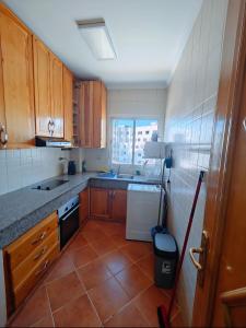 Una cocina con gabinetes de madera y piso de baldosas. en Agadir city break, en Agadir