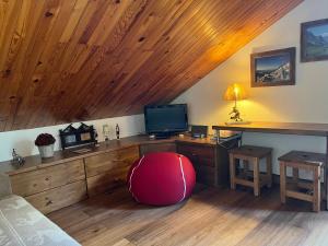 a room with a desk with a television and a red chair at Charmant appartement 3 pièces au centre, balcon sud - FR-1-464-253 in Pralognan-la-Vanoise