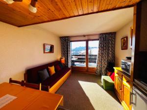 a living room with a couch and a window at Studio Cabine Les Saisies, 4 pers, Terrasse sud - FR-1-293-413 in Les Saisies