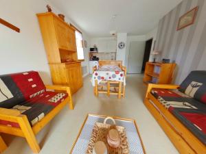 ein Wohnzimmer mit Sofa und Tisch in der Unterkunft Appartement lumineux 2 pièces avec loggia aux Rousses - FR-1-834-7 in Les Rousses + 2 Fotos