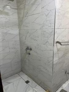 een badkamer met een douche en witte marmeren tegels bij Sphinx middle east pyramids in Banī Ghālib +63 foto's