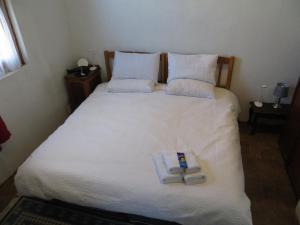 a bedroom with a bed with two towels on it at Mountain View Cottages in Nieu-Bethesda