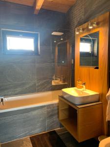 a bathroom with a sink and a tub and a mirror at Marina Liptov pri Liptovskej Mare in Liptovský Trnovec