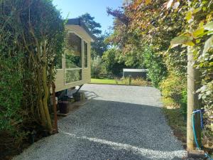 a gravel driveway leading to a tiny house at Emma 6 in Menai Bridge