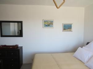 Un dormitorio con una cama y dos cuadros en la pared. en Island View Room, en Mossel Bay