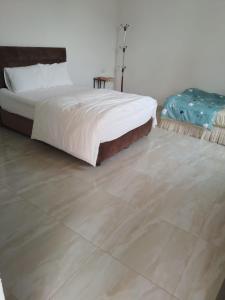 a bedroom with a bed and a tiled floor at Blue City Resort in Murayjāt