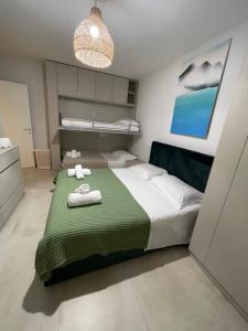 a bedroom with a bed with towels on it at San Pietro Premium Meliá Garden Apartment in Lalzit Bay