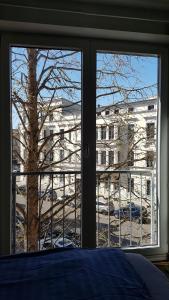 a bedroom window with a view of a building at Modernes Apartment Stadtfeld Ost Panoramafenster in Magdeburg