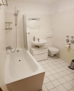 a bathroom with a tub and a sink and a toilet at Modernes Apartment Stadtfeld Ost Panoramafenster in Magdeburg