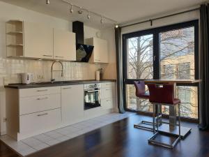 a kitchen with white cabinets and a table and chairs at Modernes Apartment Stadtfeld Ost Panoramafenster in Magdeburg