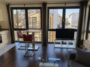 a living room with a couch and a tv at Modernes Apartment Stadtfeld Ost Panoramafenster in Magdeburg