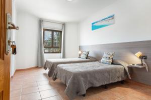 a bedroom with two beds and a window at Casa Corralejo Ian’s Dreams in Corralejo