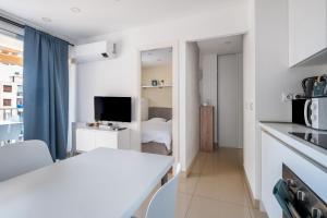 a white kitchen with a living room with a bed at Golfe Juan avec parking in Vallauris