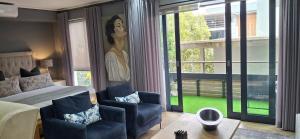 a bedroom with a bed and a chair and a large window at 112 Luxury Studio at The Gallery in Knysna