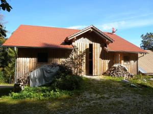 una piccola casa in legno con tetto rosso di Grillnhäusl a Wegscheid