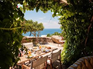 a table set for a meal with the ocean in the background at Belvedere Mykonos - Hilltop Rooms & Suites - The Leading Hotels of the World in Mikonos +62 photos