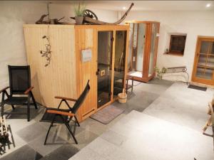 a room with two chairs and a wooden cabinet at Grillnhäusl in Wegscheid